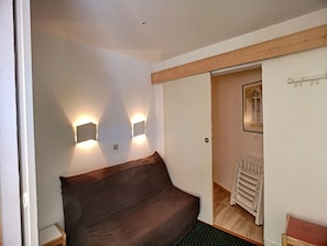 Cozy retreat with a single bed, bedside table, and wall-mounted light fixture.