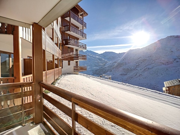 Overlooking snow-covered mountains, this building offers stunning views from its multiple balconies.