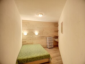 Cozy retreat with a small bed, wooden panel design, and ample storage.