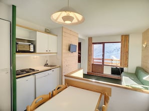 Enjoy meals at the dining table, with a view of the outdoors through the window.