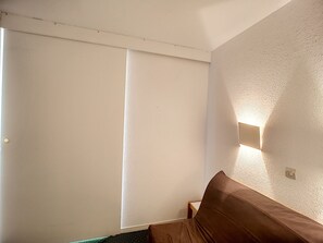 Cozy retreat with a single bed, bedside table, and wall-mounted light.