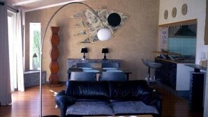 A modern living room with a sofa, a coffee table, and a unique wall art piece.