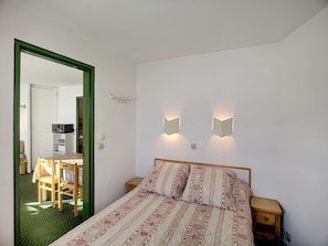 Cozy retreat with a single bed, nightstand, and mirror.