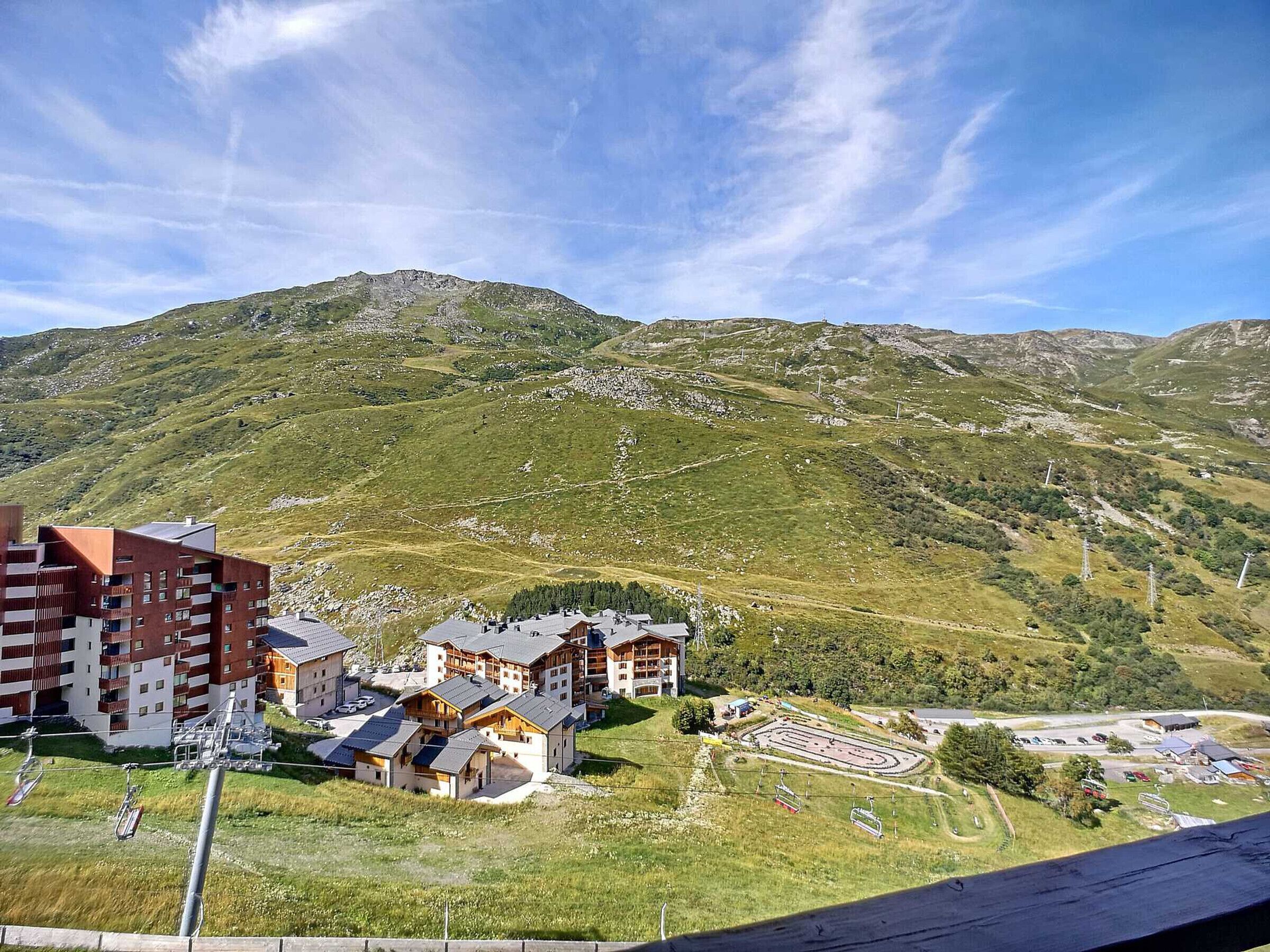 A mountainous area with a ski resort, including buildings and ski lifts.