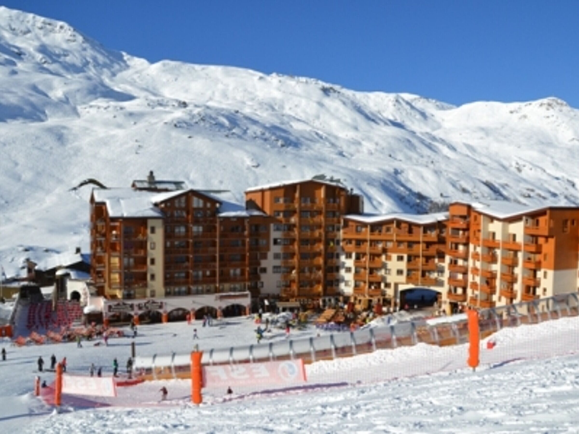 A multi-story hotel with a ski slope in the foreground.