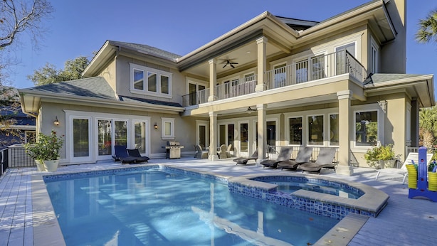 A two-story house with a swimming pool, outdoor seating, and a covered patio area. - Sunset Rentals | Capri 2 (Hilton Head Island)