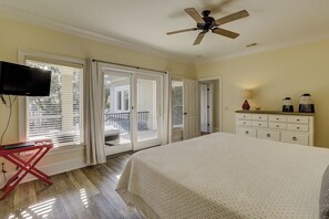 Un dormitorio con cama, ventilador de techo, cómoda y televisor.