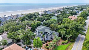A residential area with houses, a beach, and a road. - Sunset Rentals | Capri 2 (Hilton Head Island)