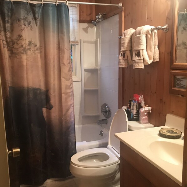 A bathroom with a toilet, shower, and sink. - Cozy Cabin in the Smoky Mountains (Sevierville)