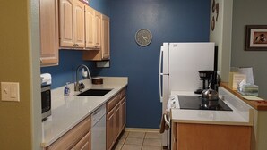 A compact kitchen with wooden cabinets, a sink, a stove, and a refrigerator. - Closest building to the main lift. (Frisco)