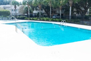 A rectangular swimming pool with clear blue water, surrounded by a white deck and a black metal fence. - Fairway Dunes 27 - Screen Porch Golf Course View! (Isle of Palms)
