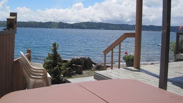 A deck with a view of a lake and distant hills.