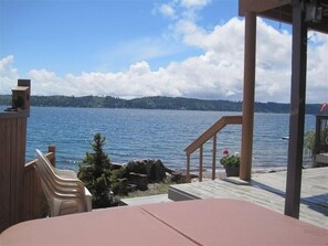 Una terraza con vistas a un lago y colinas distantes.