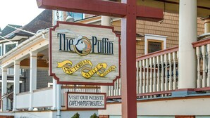 A hotel sign with a duck logo, a Victorian-style name, and a website address. - Stay in the Heart of Cape May at the Charming Rose Suite (Cape May)