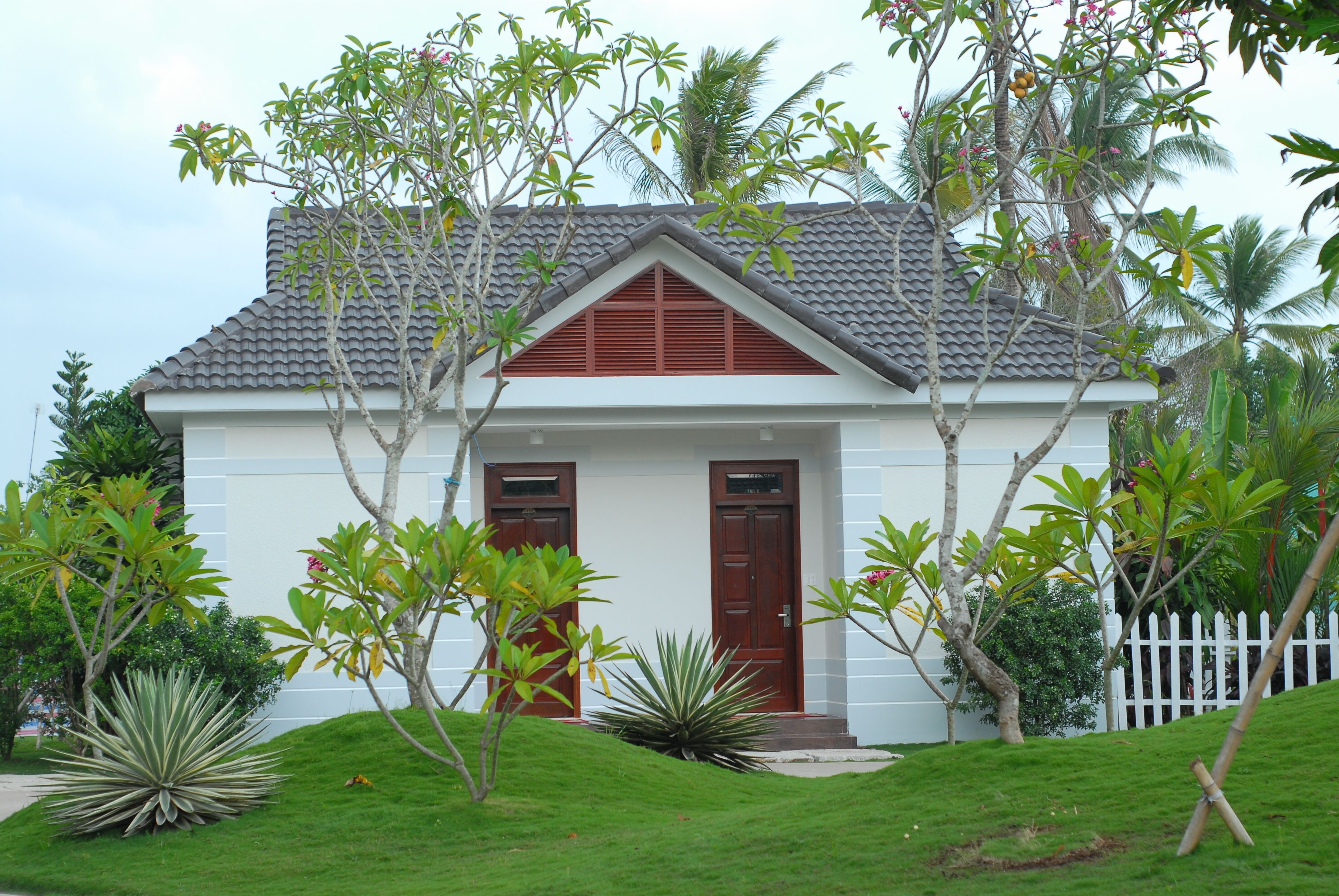 A two-story house with a white exterior and a grey tiled roof.