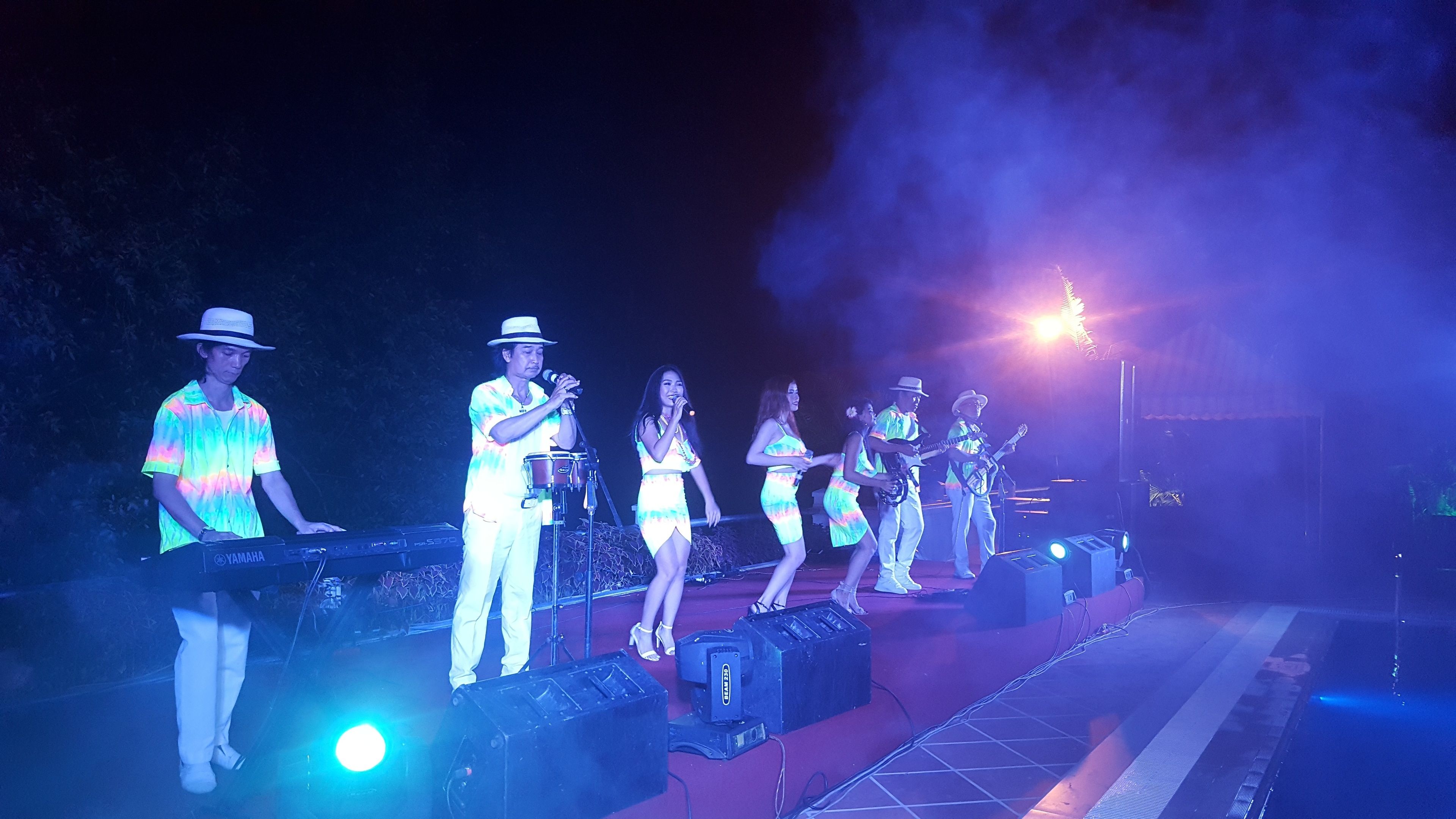 A band performing on a stage with musical instruments and a keyboard.