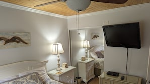 A bedroom with a bed, bedside tables, a lamp, a TV, and a mirror. - "Couples & Family Getaway," 1st Floor, King & Queen Beds, Pool, 42" HDTV's, WIFI (Hilton Head Island)