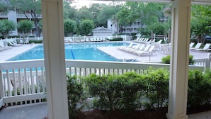 A pool area with lounge chairs and a white picket fence. - "Couples & Family Getaway," 1st Floor, King & Queen Beds, Pool, 42" HDTV's, WIFI (Hilton Head Island)