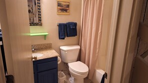 Een bad/douchecombinatie, een haardroger, handdoeken, zeep