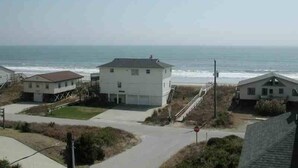 A coastal residential area with houses, a clear sky, and the ocean in the background. - Panoramic Ocean & Sound Views, 2 min walk to beach, Sleeps 8-10, Emerald Isle (Emerald Isle)
