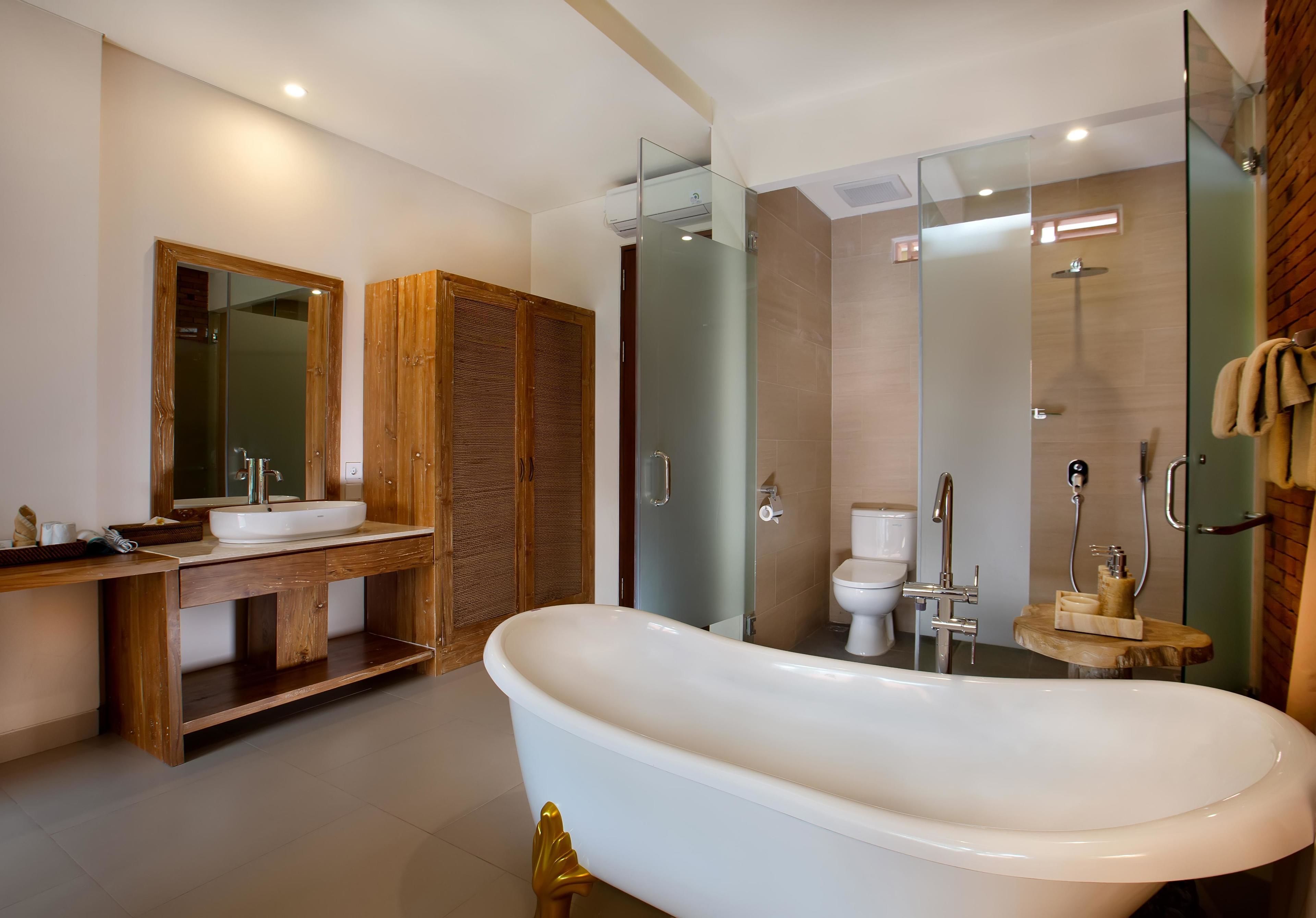 A modern bathroom with a freestanding bathtub, a wooden vanity with a mirror, and a glass-enclosed shower area.