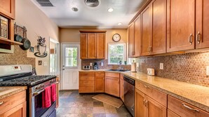 Una cocina con armarios de madera, estufa y salpicadero de azulejos.