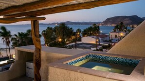 A rooftop pool with a view of the sea and mountains.