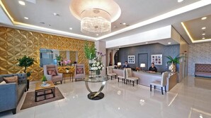 A modern hotel lobby with a reception desk, seating area, and a chandelier. - Amethyst Boutique Hotel Cebu powered by Cocotel (Cebu City)