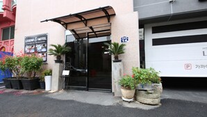 The entrance to a building with a sign for 'Legend Motel' and a parking sign indicating '14'. - Legend Motel (Geoje)