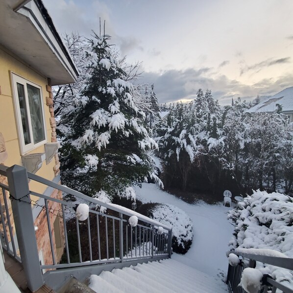 A snow-covered outdoor area with a staircase leading to a building entrance, surrounded by snow-laden trees and a clear sky. - Nikko Ikoi Hotel (Nikko)