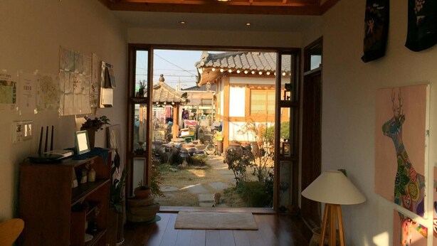 A traditional Japanese interior with tatami mats, a shoji screen door, and a view of a traditional garden. - Doran Doran Guesthouse (Gyeongju)
