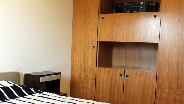 Ein Hotelzimmer mit einem Bett, einem Holzschrank und einem kleinen Nachttisch.