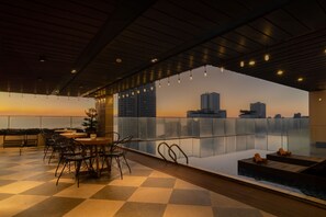 Una piscina al aire libre, sillones reclinables de piscina