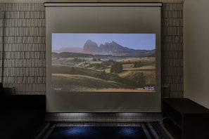A projection screen displaying a landscape with mountains and a house, with a temperature of 32 degrees and time 15:25. - Soshigaya Apartment (Tokyo)