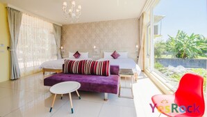 A modern bedroom with a large bed, a sofa, a small table, and a view of greenery outside. - Tourist Home B&B (Luodong)