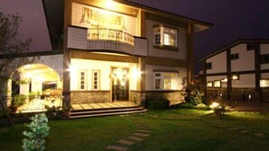 A two-story house with a balcony on the second floor, a front porch, and a well-lit entrance. - Tourist Home B&B (Luodong)