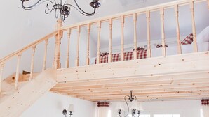 A spacious living area with a wooden staircase, a sofa, a coffee table, and a TV. - Namubyeol (Gapyeong)