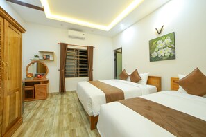 A hotel room with two beds, wooden wardrobe, a mirror, a window with curtains, and a wall-mounted air conditioner. - Nhu Y Homestay (Da Nang)