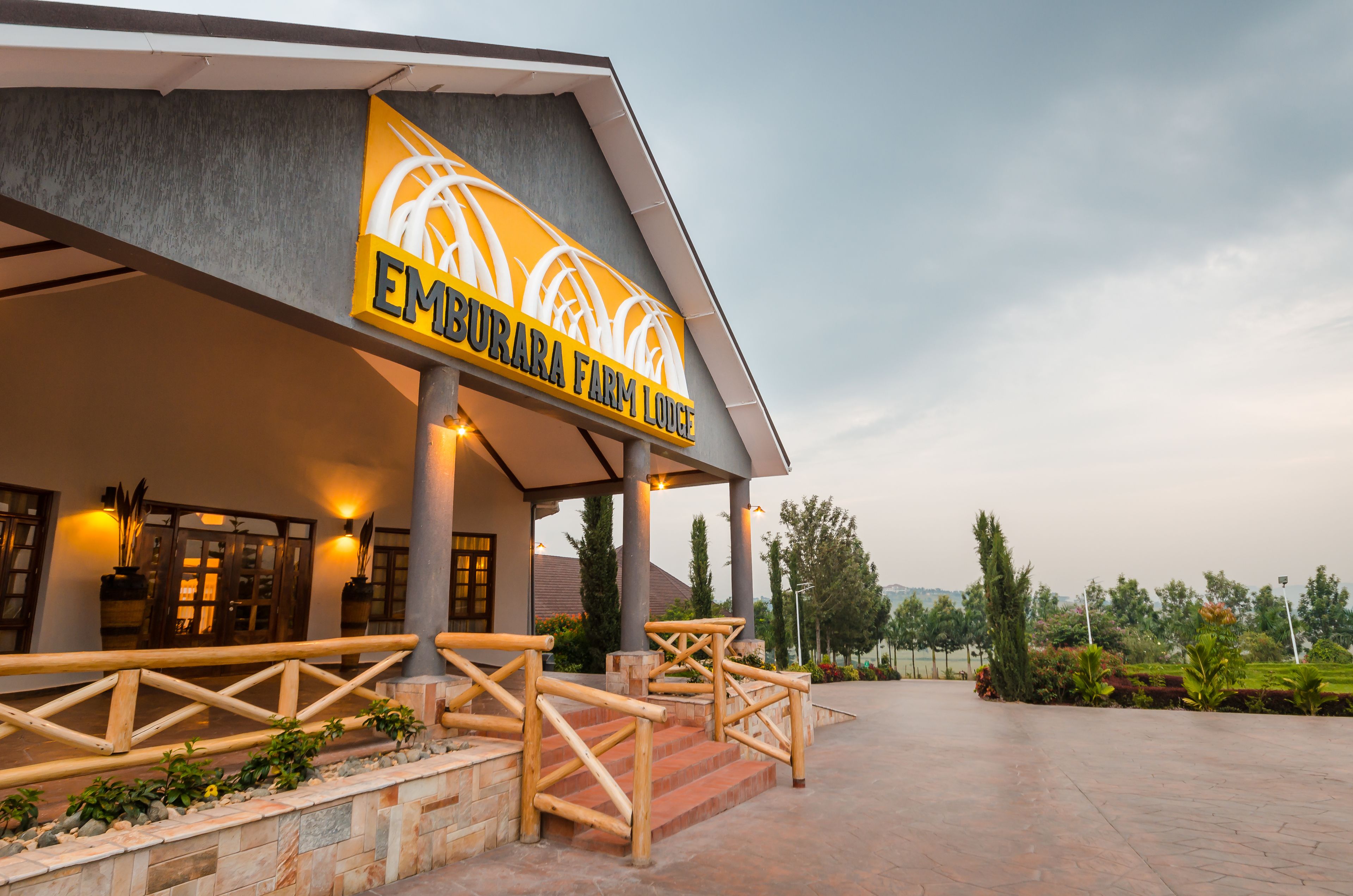 L’extérieur du Emburara Farm Lodge se distingue par une enseigne bien visible, une entrée abritée et un jardin aménagé.