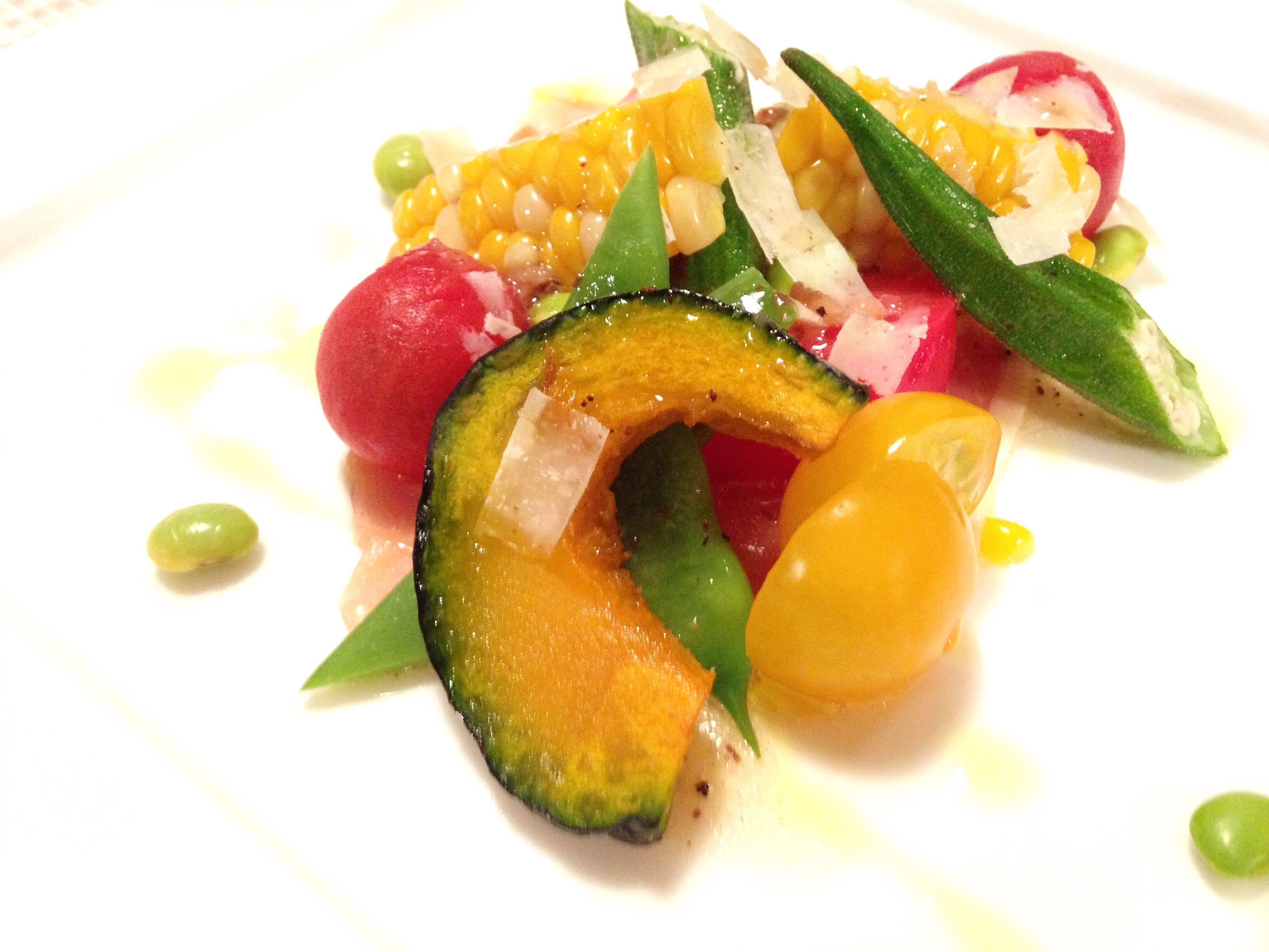 A plate of colorful food with various vegetables and a radish.