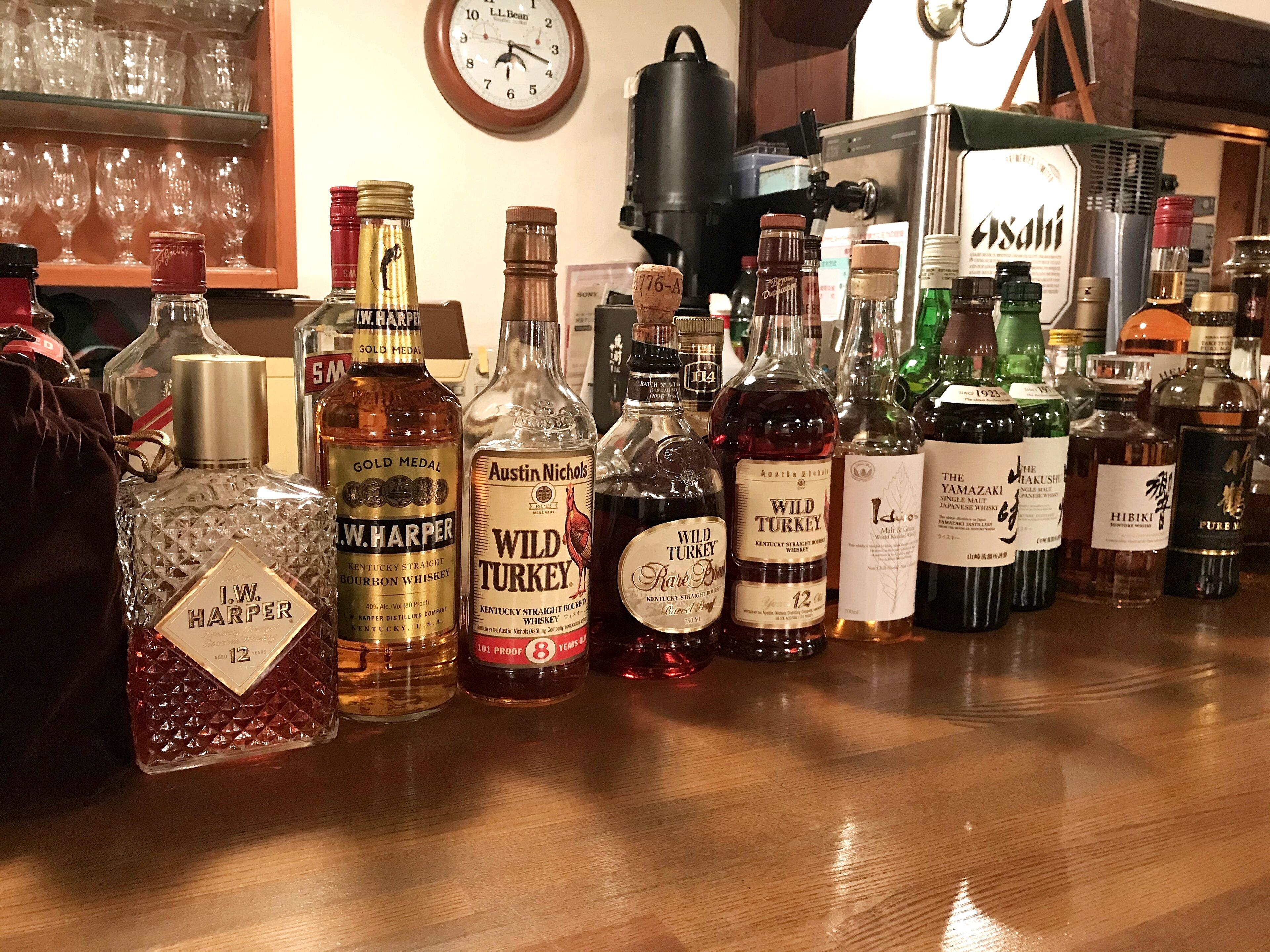 Variedad de botellas de licor sobre una barra de madera.