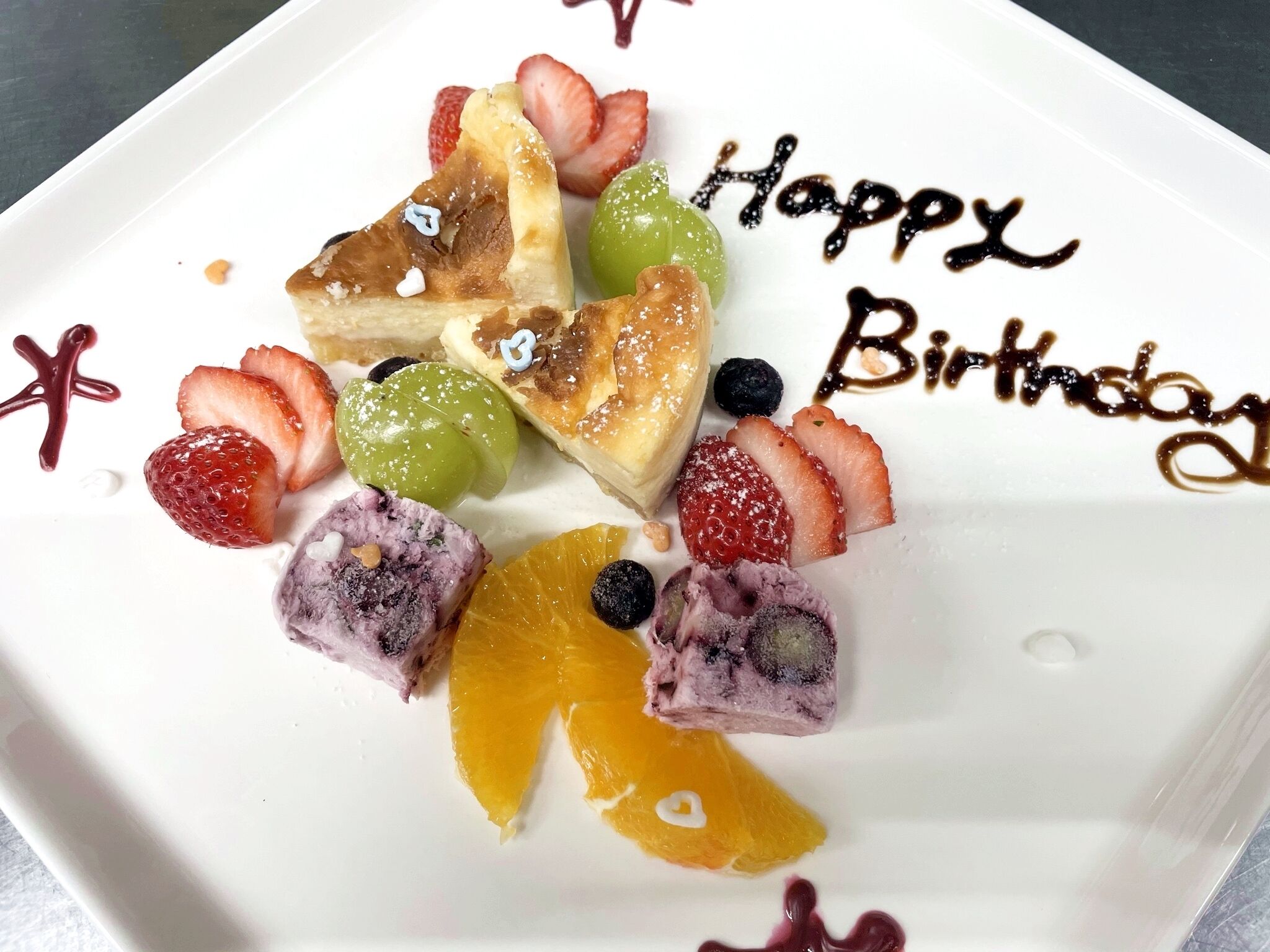 A dessert plate with various fruits and a 'Happy Birthday' message.