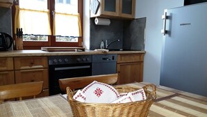 Une cuisine avec des meubles de rangement en bois, une cuisinière, un évier et un réfrigérateur.
