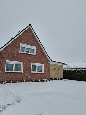 A red brick house with two windows and a small attached garage.