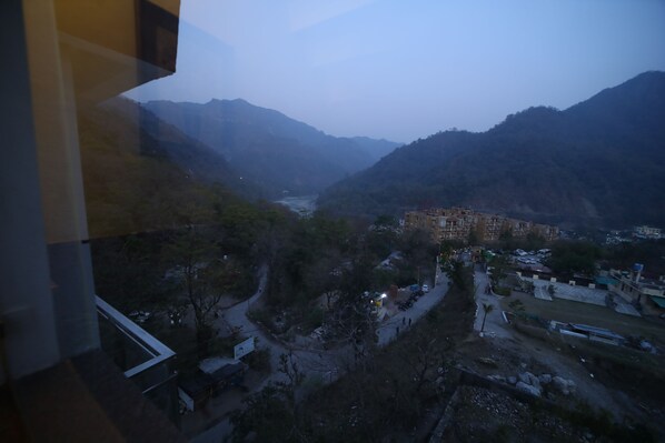A mountainous landscape with a valley, a building complex, and a river. - Kamay The Grand Alova (Narendranagar)