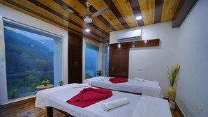 A room with two beds, a large window, wooden ceiling, and an air conditioning unit. - Kamay The Grand Alova (Narendranagar)