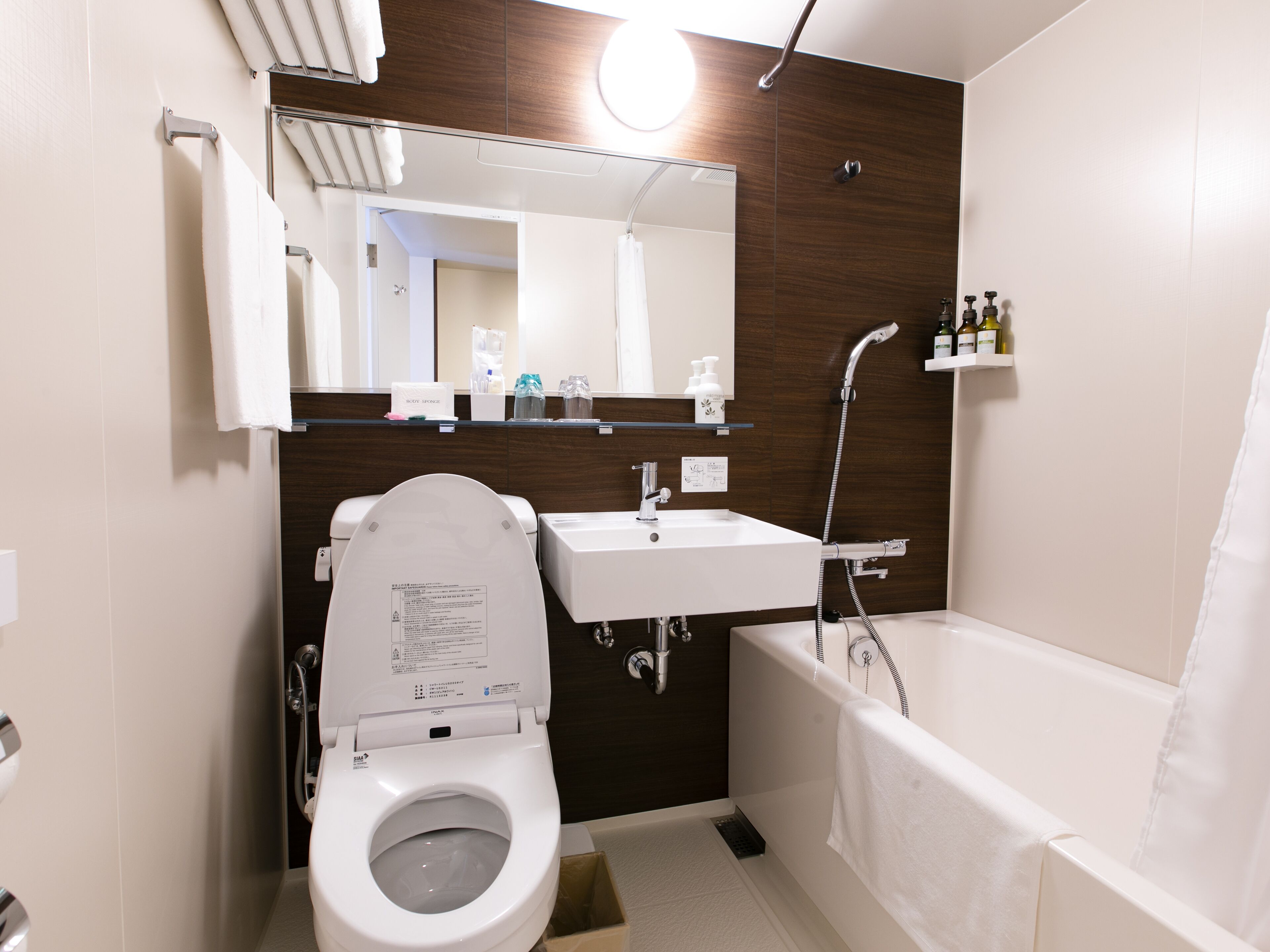 A modern bathroom with a toilet, sink, and bathtub.