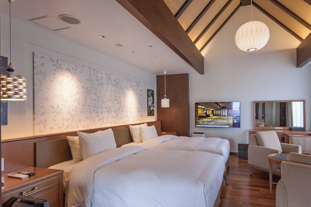 Een hotelkamer met een groot bed, een televisie, een bureau en een stoel.