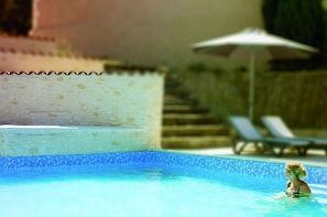 Utomhuspool, parasoller och solstolar