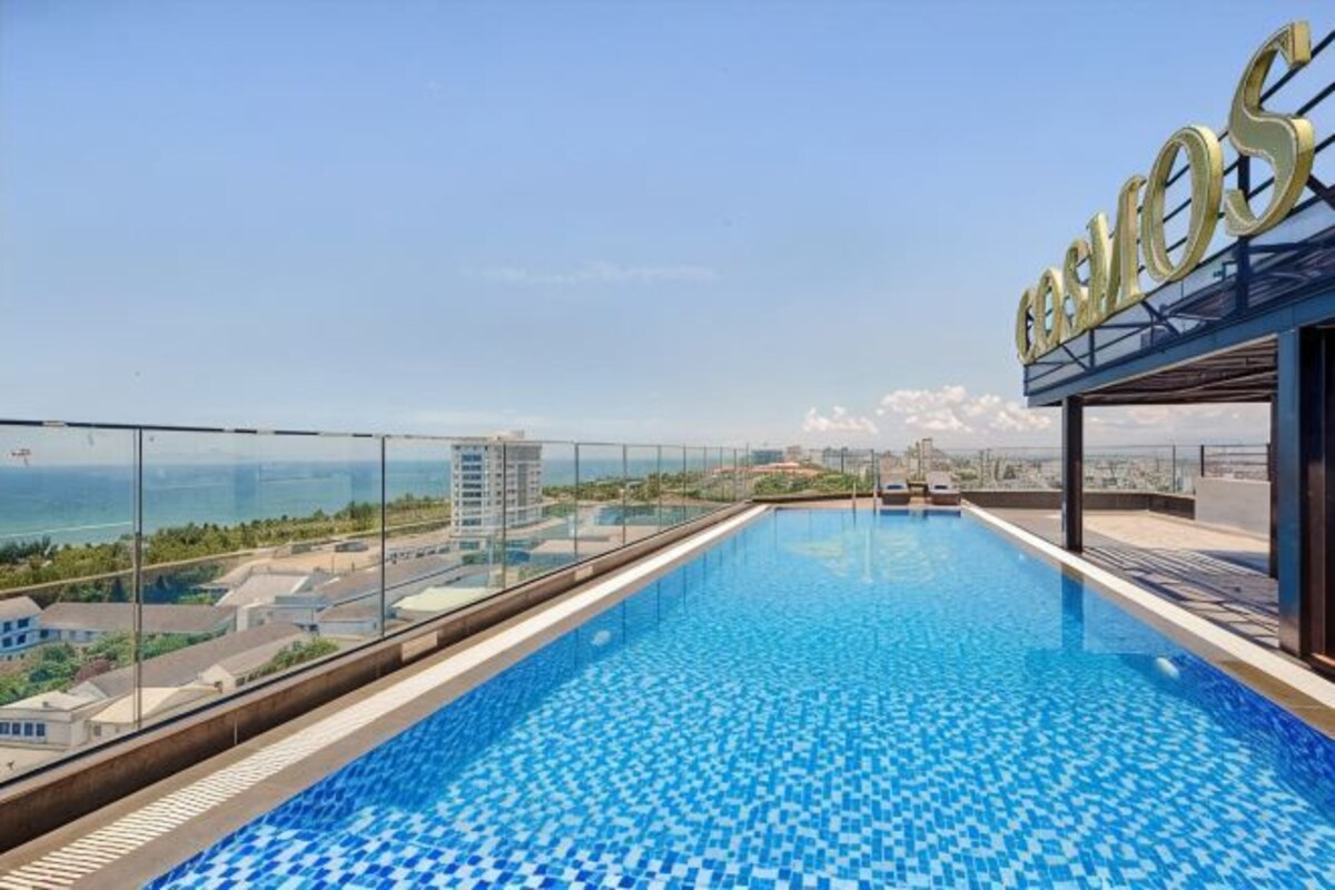 Piscina infinita no terraço com vista clara para o oceano e para a paisagem urbana.